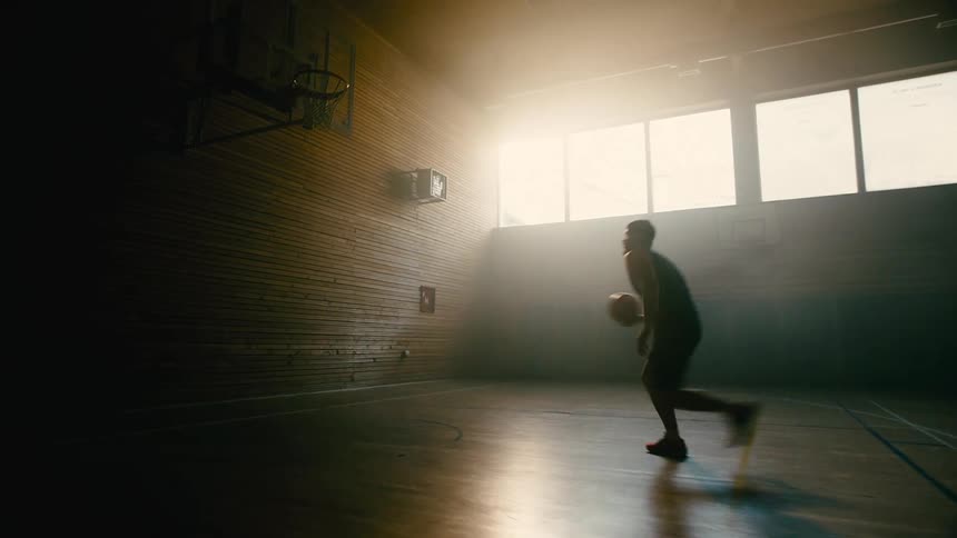 Man on a basketball court practicing an attack and a shot