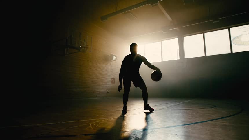 A man playing basketball in a room