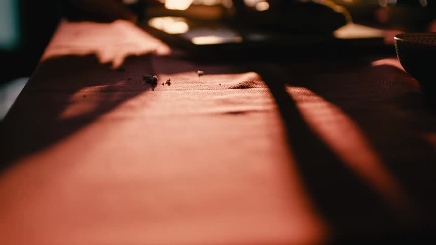 A person slicing food on a cutting board on a table
