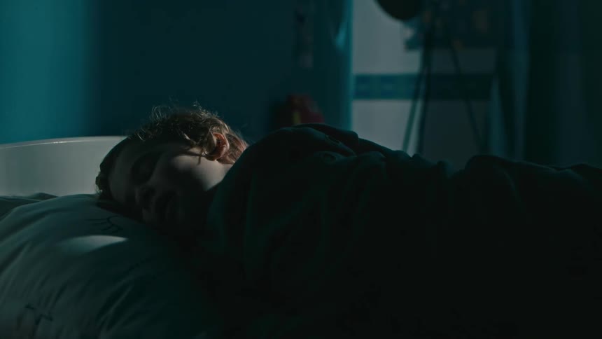 Silhouette of an adult putting his sleeping child to bed