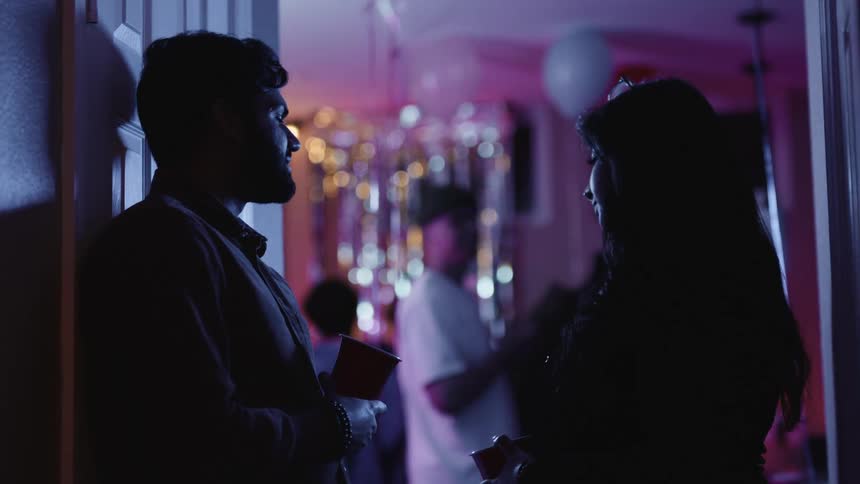 A man and woman chat in a night club