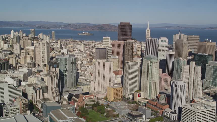 Aerial panorama of a metropolis with commercial and urban skyscrapers on the seafront with islands on the horizon