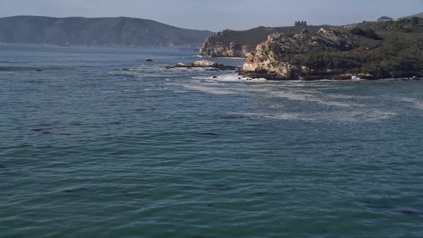 Aerial and natural scenery of a bay with calm sea and mountains around