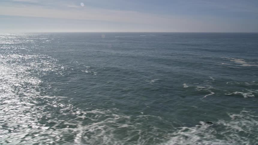 Aerial panorama of a vast ocean with sunlight reflection