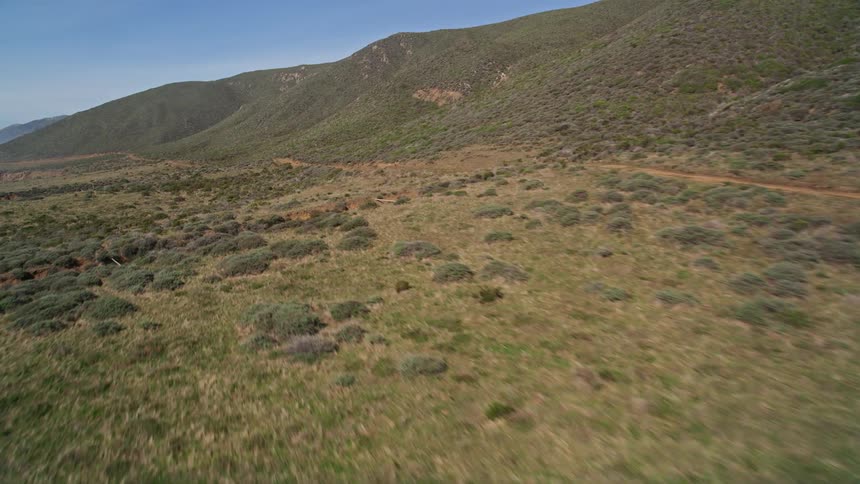 Panorama of mountains with vegetation on a cloudless blue sky day