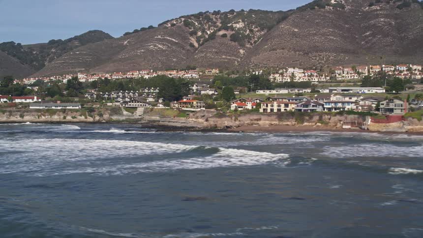 Waves crash against the shore of the town