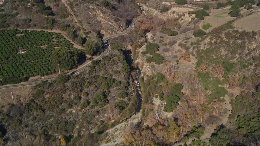Aerial aerial panorama of mountains and erosion with a road with vehicle traffic