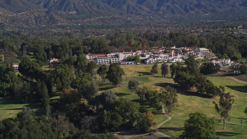 Aerial panorama of a hotel zone in a rural environment surrounded by trees and mountains