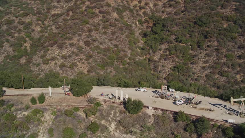 Aerial panorama of trucks and cranes on a mountain peak and plateau