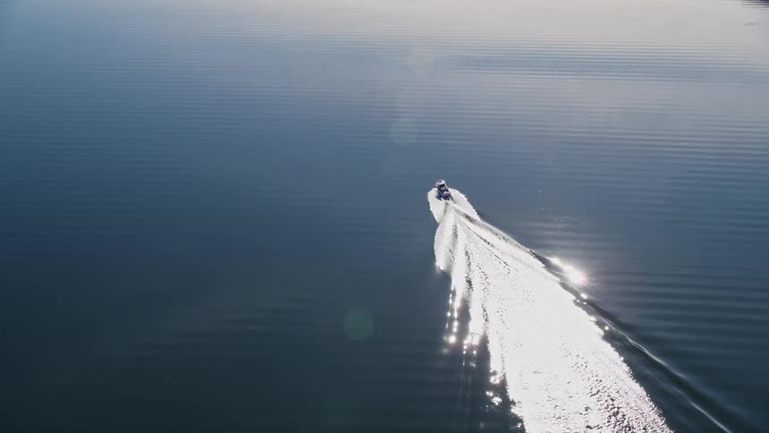 A boat powers through water near some islands