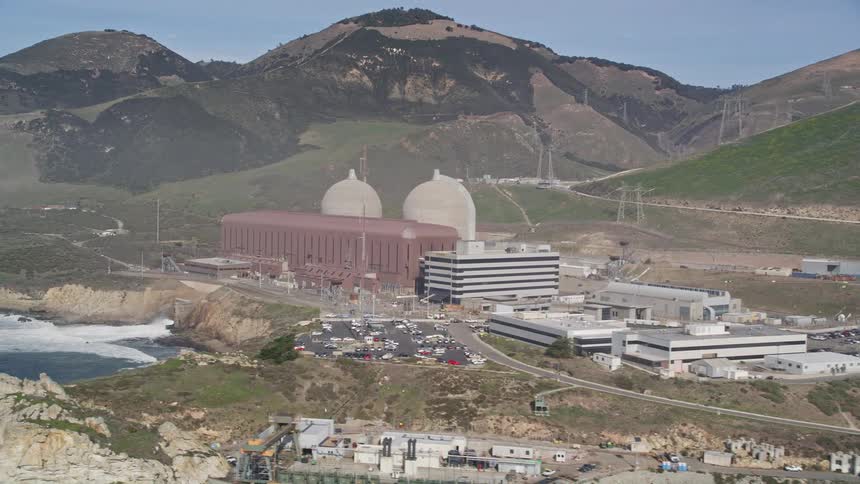 An aerial view of a large power plant along the water