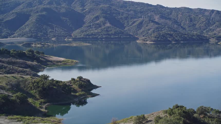 Aerial panorama of mountains with vegetation and calm waters in the center