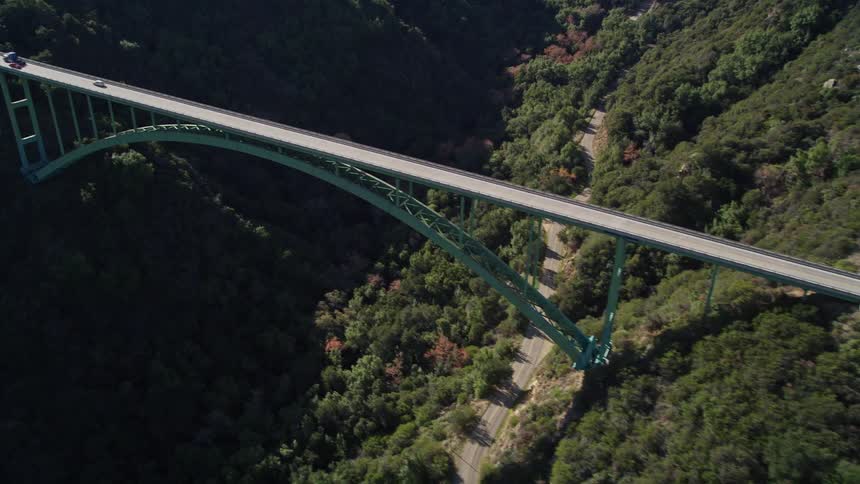Vehicles travel over the bridge in the mountains