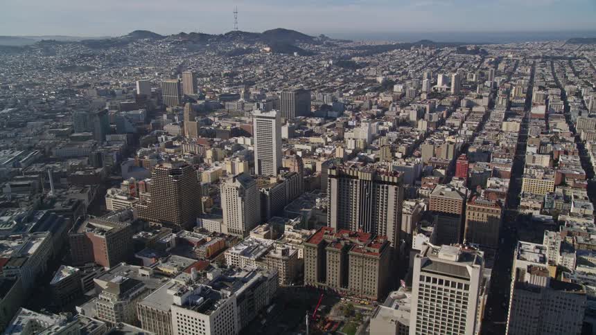 Aerial panorama of a metropolis with skyscrapers and mountains on the horizon