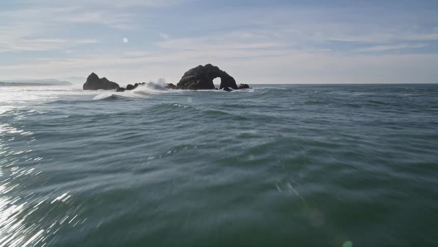 Aerial view of a natural rock arch in the ocean near the coast