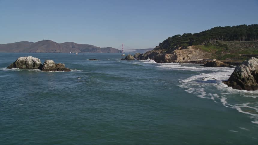 A rocky coastline gives way to a large bridge