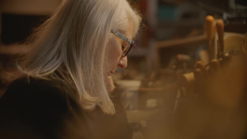 Side portrait of a woman sitting at an office desk with tools