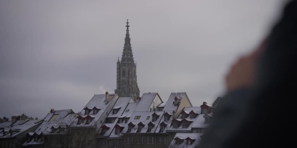 Person taking pictures of the Bern, Switzerland skyline, with the Cathedral of Bern in the distance