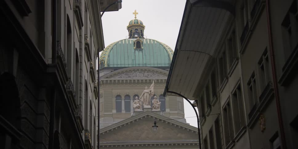 Narrow street view of the dome of the Parliament building in Bern, Switzerland