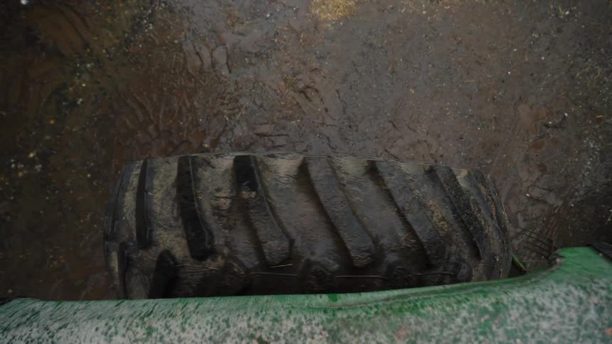 Close up of a tractor wheel driving in the mud