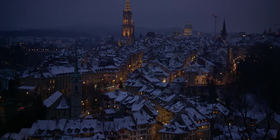 Panorama of Bern, Switzerland seen from above at night with the roofs covered in snow