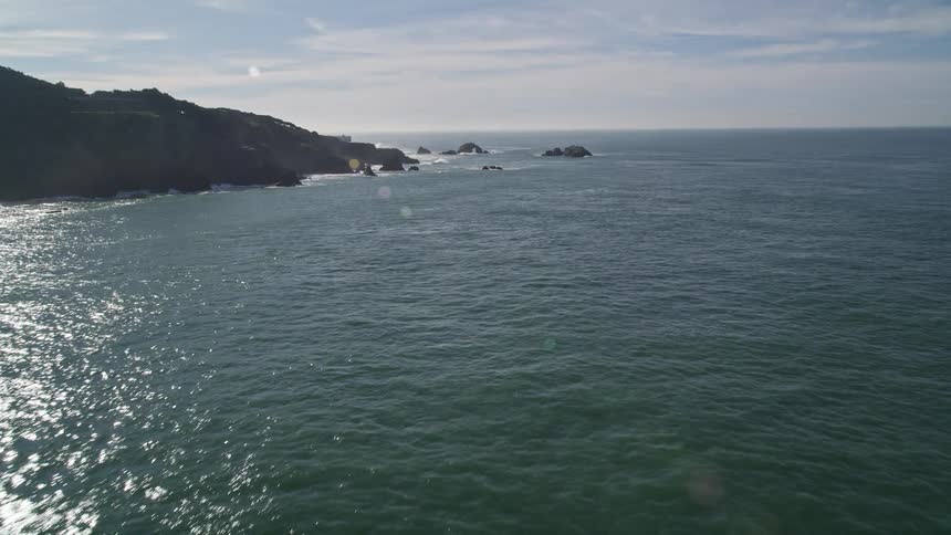 Waves splashing against rocks along the coast as they roll into shore