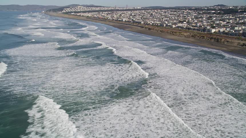 Waves are crashing against the shore of the town