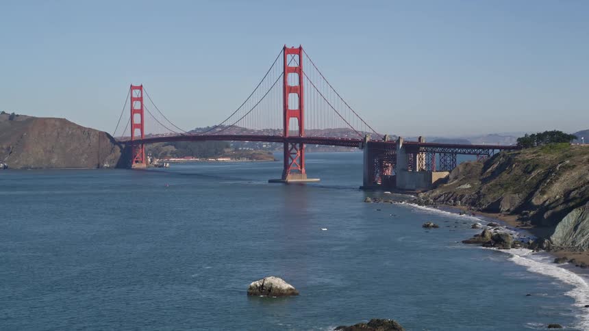 Aerial view of the blue sea and a long bridge connecting city hills and islands