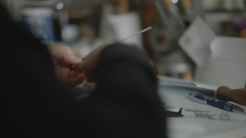 Hands of a woman with a tool on a silver rod
