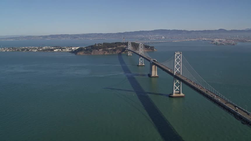 Aerial view of cars driving across bridge over water