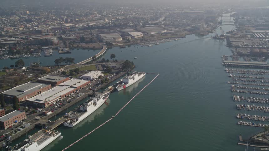 Aerial panorama of a sea canal with yachts at docks cargo boats and a city around