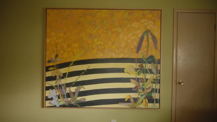 Large framed painting hangs on the wall near a door