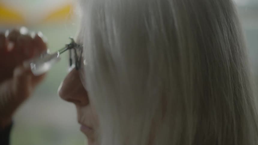 A woman puts on her glasses