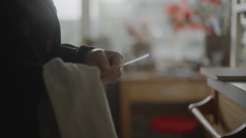 A clip of an old lady cleaning a tool with a napkin