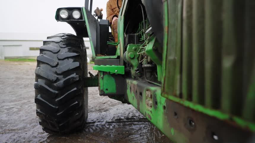 View of the wheel of an agricultural tractor being driven by a person