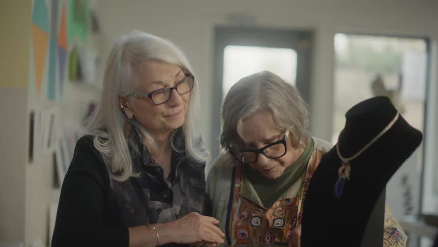 Two old ladies inside a jewelry store talking and analyzing