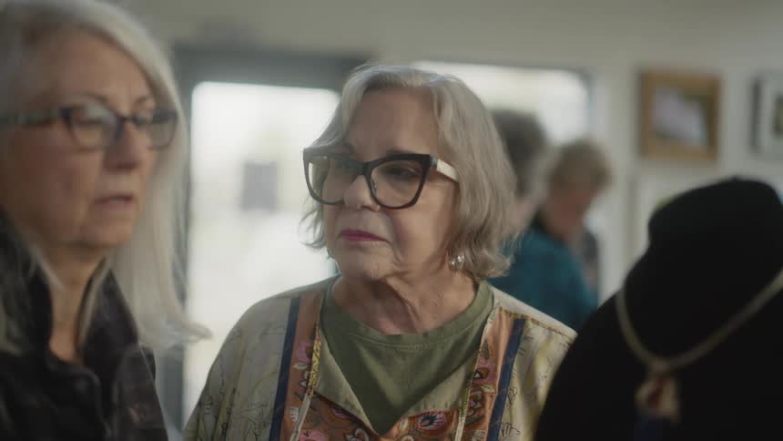 A clip of two old ladies having a conversation with others