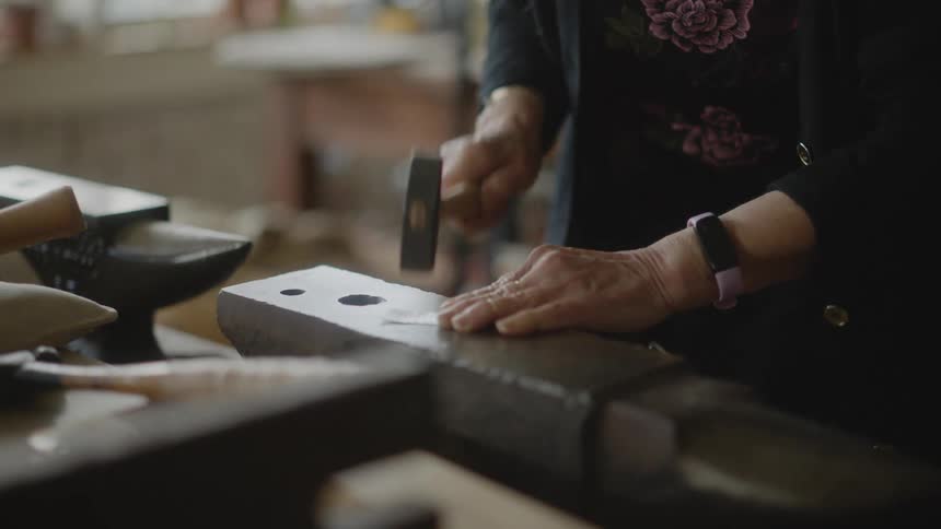 Lady hammering a silver jewelry