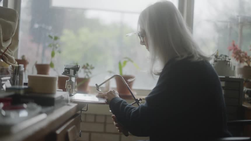 A female sculptor cutting an object