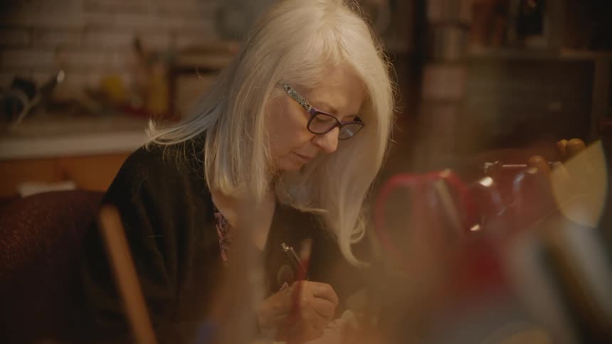 An elderly artist drawing with a pen and paper