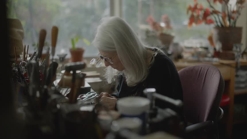 Lady sitting at an office desk carefully holds an abstract object with her hands