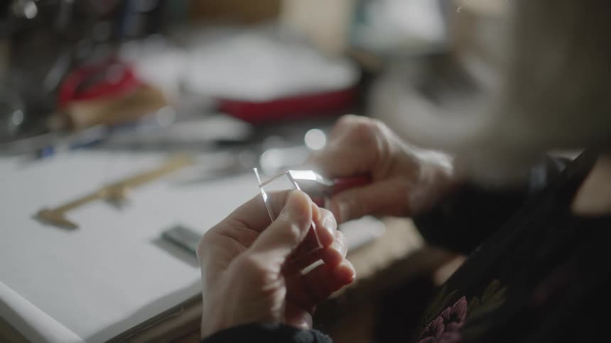 A woman is using a tool to bend an object