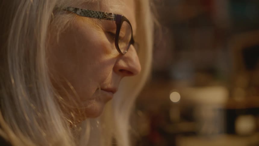 Close up of the face of a woman wearing reading glasses