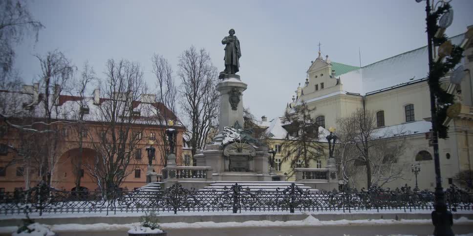 A bus passes by the Adam Mickiewicz monument in front of the Carmalite Church in Warsaw, Poland