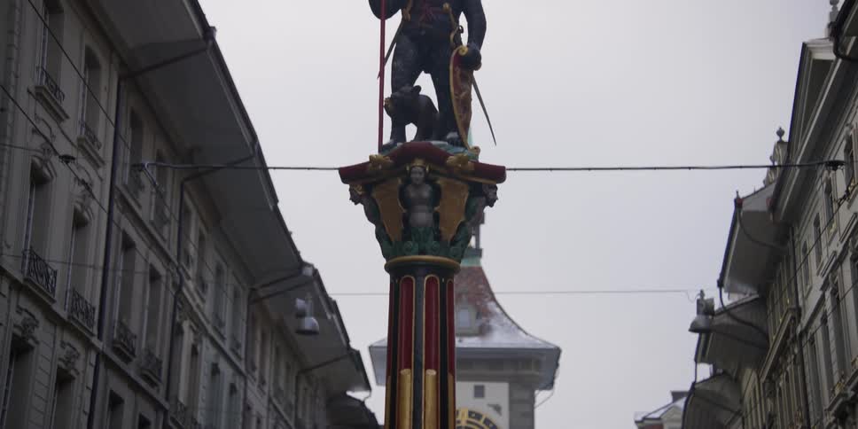 Upward scanning view of the Zahringerbrunnen bear statue in front of the Zytglogge Tower in Bern, Switzerland