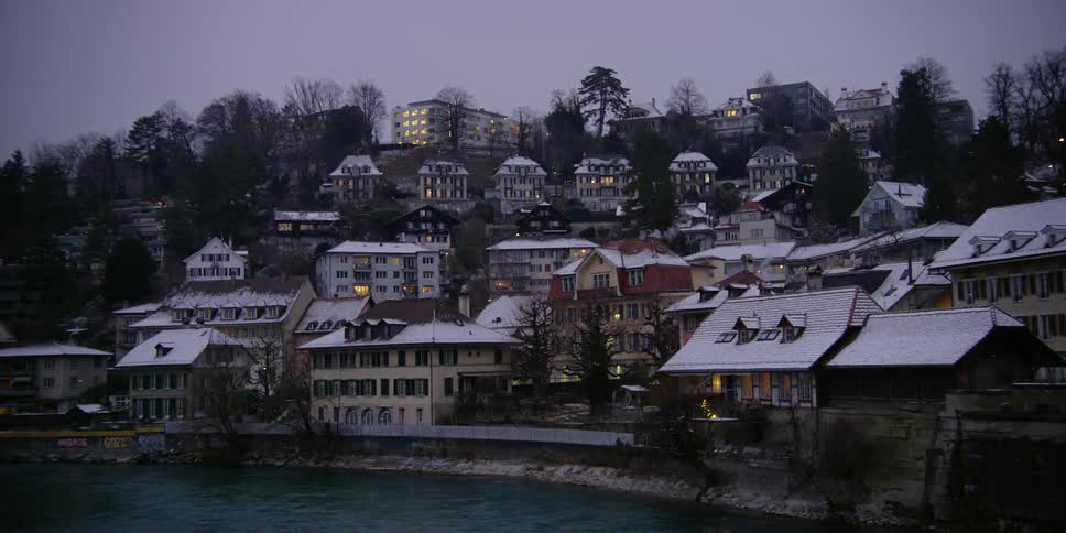 The Aare River and homes in Bern, Switzerland covered in snow at dusk