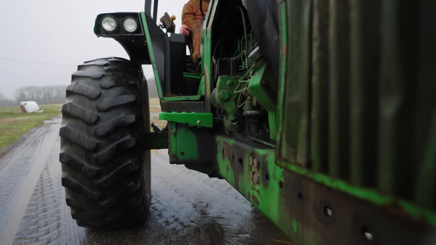 A tractor is driving in the mud