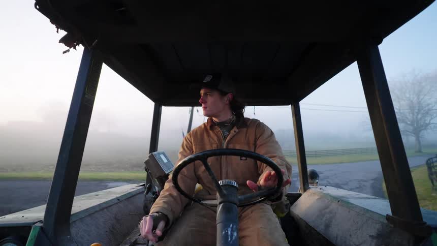 A young man drives a tractor down a road