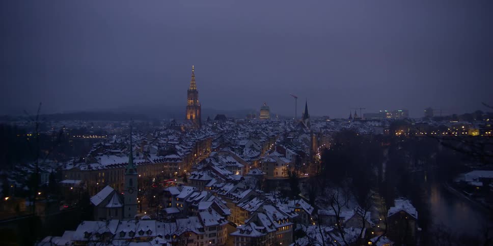 A winter's night view of the city of Bern, Switzerland with the Bern Munster cathedral standing tall in the distance.