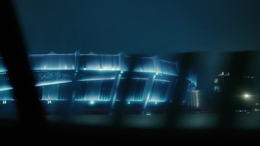Traffic runs by the stadium at night